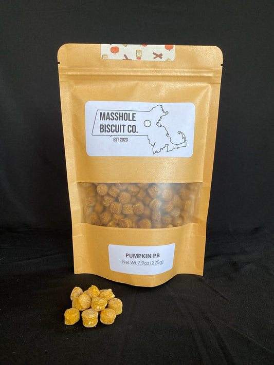 Masshole Biscuit Co Medium Training Treat Dot Bag in the pumpkin peanut butter flavor. A small handful of the all natural human grade training treats are in front of the bag.